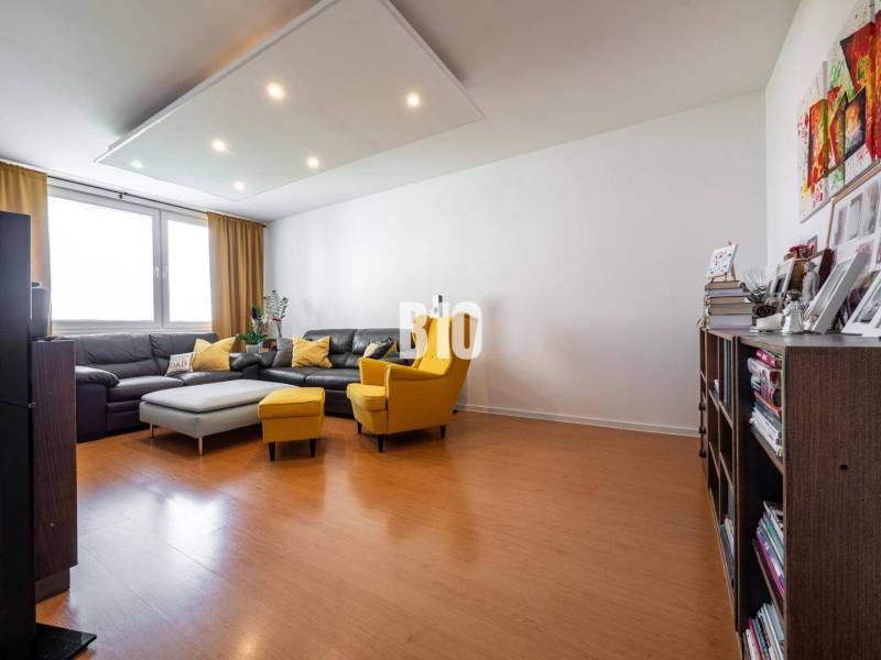 Living room in a 4-room apartment with a wooden decor floor and comfortable furniture.