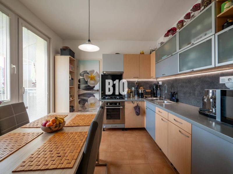 A kitchen in a 4-room apartment with a dining table and built-in appliances.
