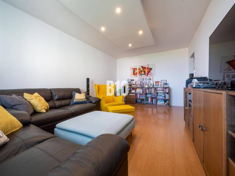Living room in a 4-room apartment with a wood-patterned floor and comfortable seating.