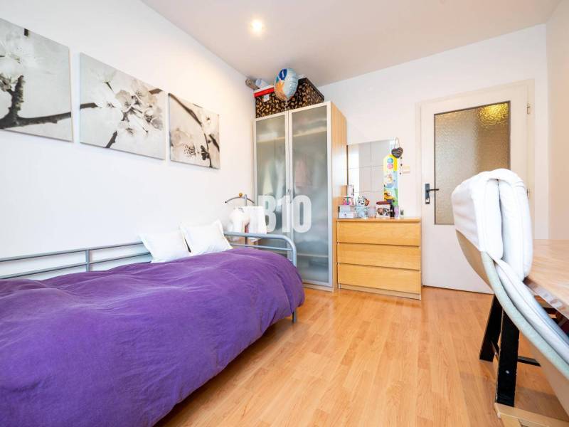 A room in a 4-room apartment with a single bed, a wardrobe, and a floor with a wooden decor.