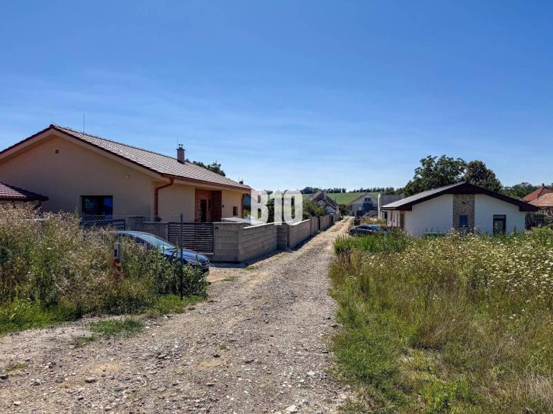 Family houses near a road surrounded by grass in Čeľadice, residential plots.