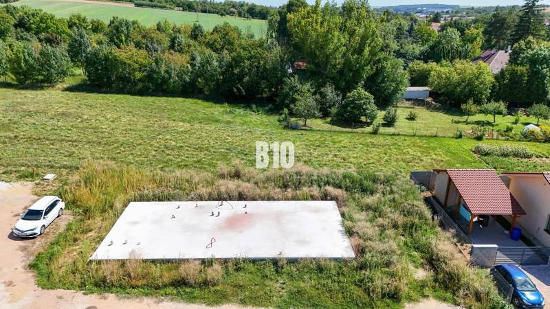 Building plot in Čeľadice, green landscape with a concrete foundation and a car.