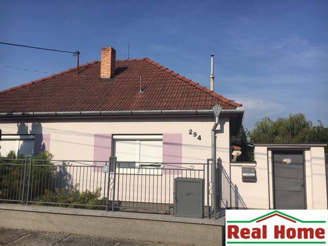 A family house in Čierna Voda with a white facade and a brick roof.