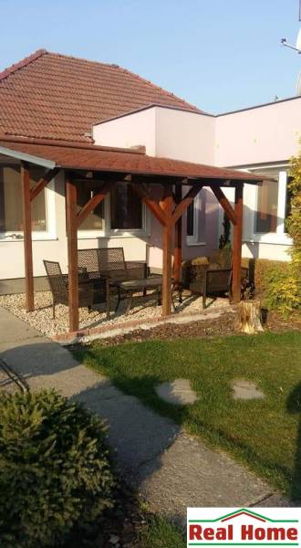 A family house in Čierna Voda with a terrace, garden furniture, and a green lawn.