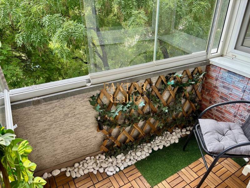 A glazed balcony with wooden decor and plants in a 2-room apartment.