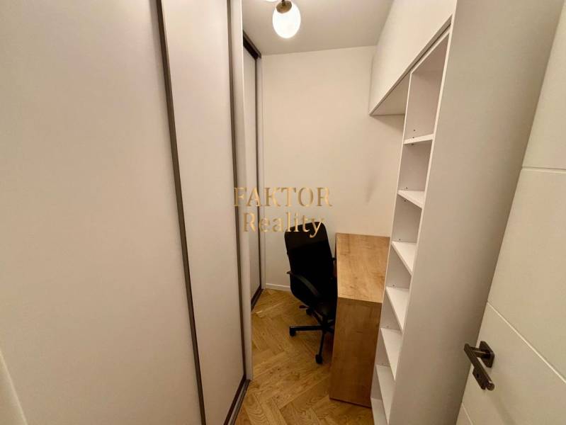 A small study in a 2-room apartment with a wooden decor floor and built-in wardrobes.