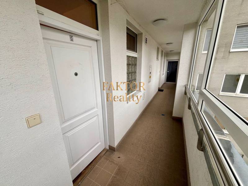 Hallway in a 2-room apartment with white doors and tiles.