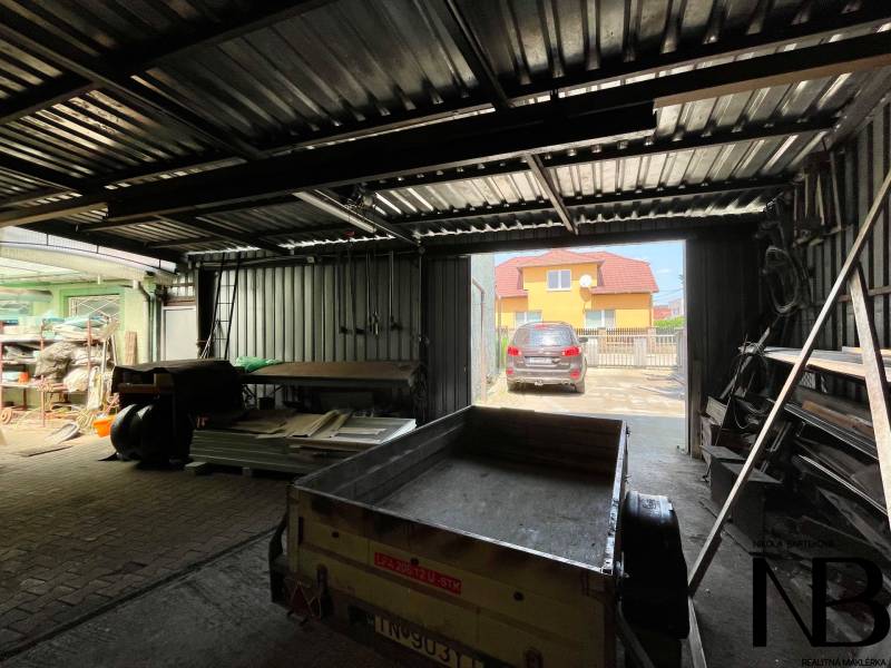 A garage in a family house with equipment and a trailer on Záblatská Street in Trenčín.