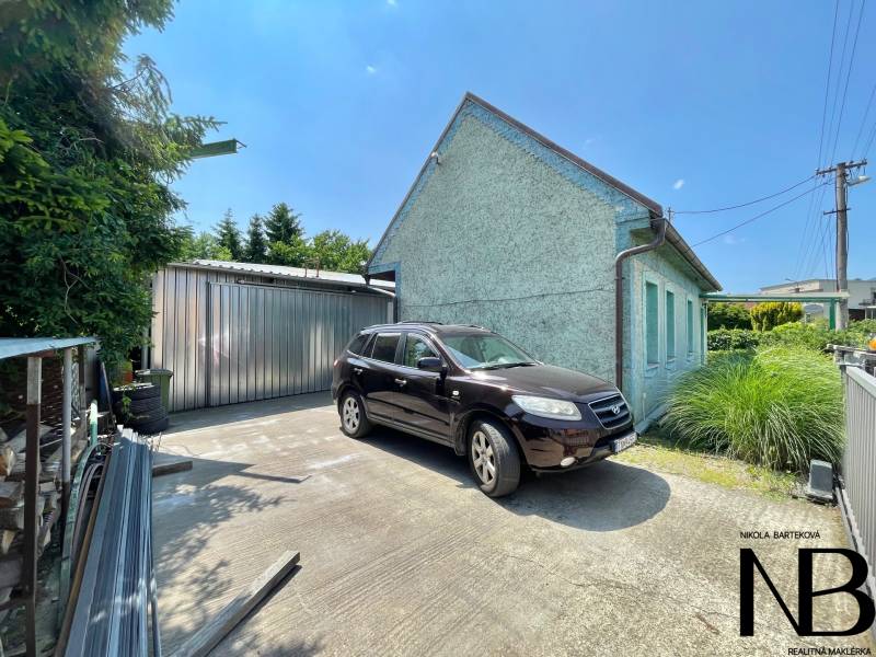 A family house on Záblatská Street in Trenčín with a car and a metal garage.
