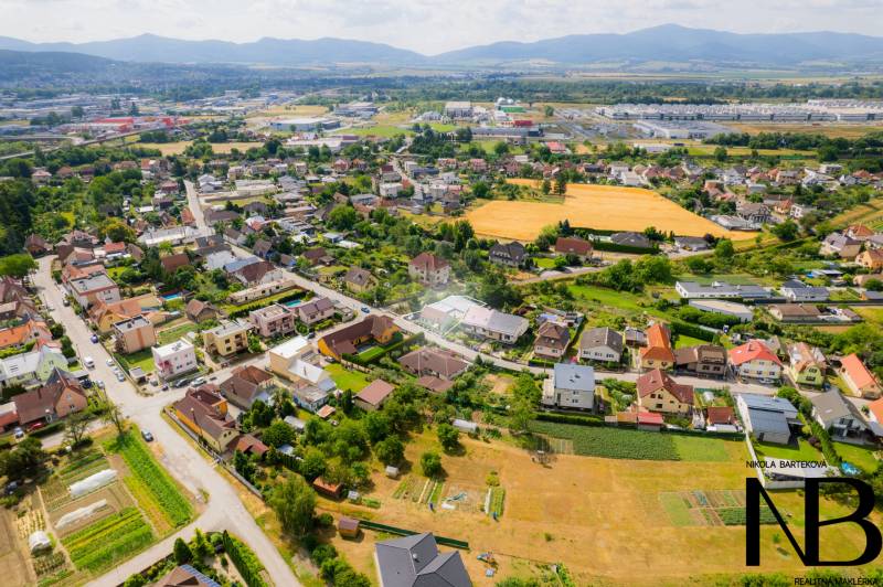 Aerial view of the Záblatská district in Trenčín with family houses and gardens.