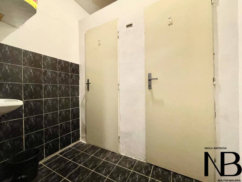 Dark tiles, white walls, and doors in the interior of a family house.