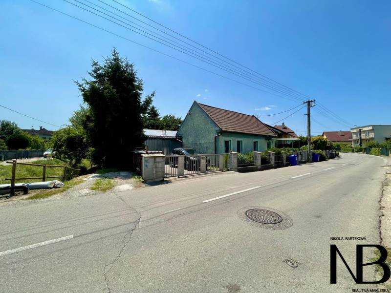 A family house on Záblatská Street in Trenčín, with garbage bins next to the fence.