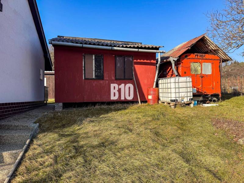 Red garden cottages in the Gardens in Nitra with a plastic water tank.