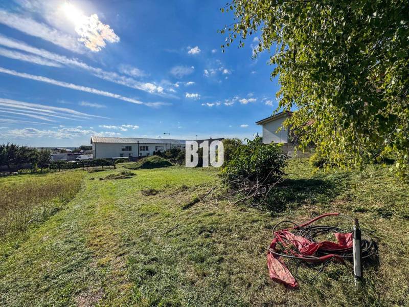 Land for residential use in Nitra, grassy area with greenery and sunny sky.