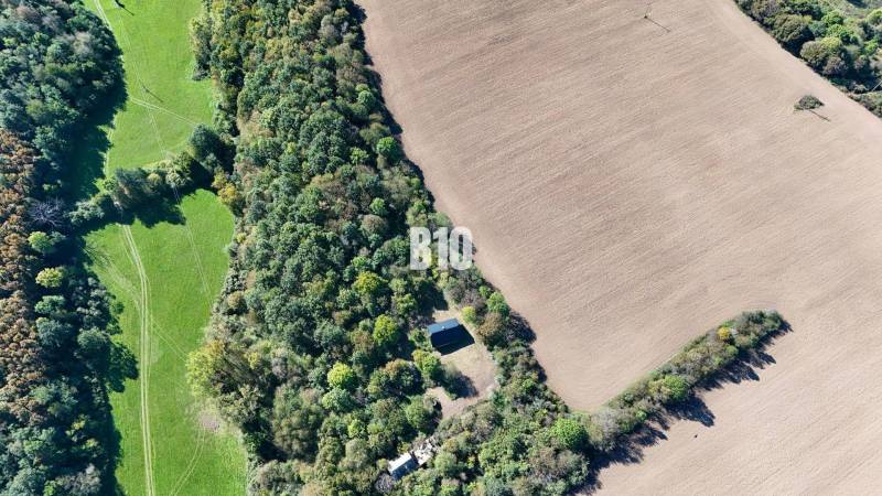 An aerial view of a cottage in Lackov surrounded by fields and forest.