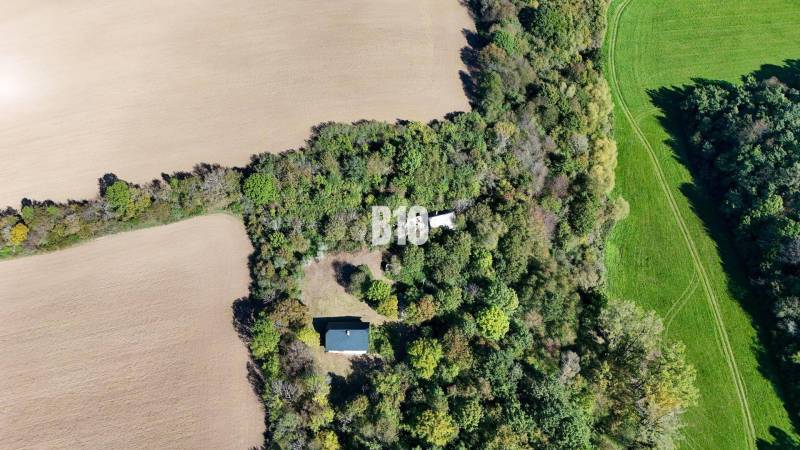 Aerial view of a cottage in Lackov surrounded by fields and forest.