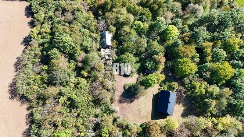Aerial view of a cabin in Lackov surrounded by dense forest and a clearing.