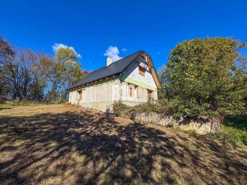 A cottage in Lackov surrounded by nature under a blue sky.