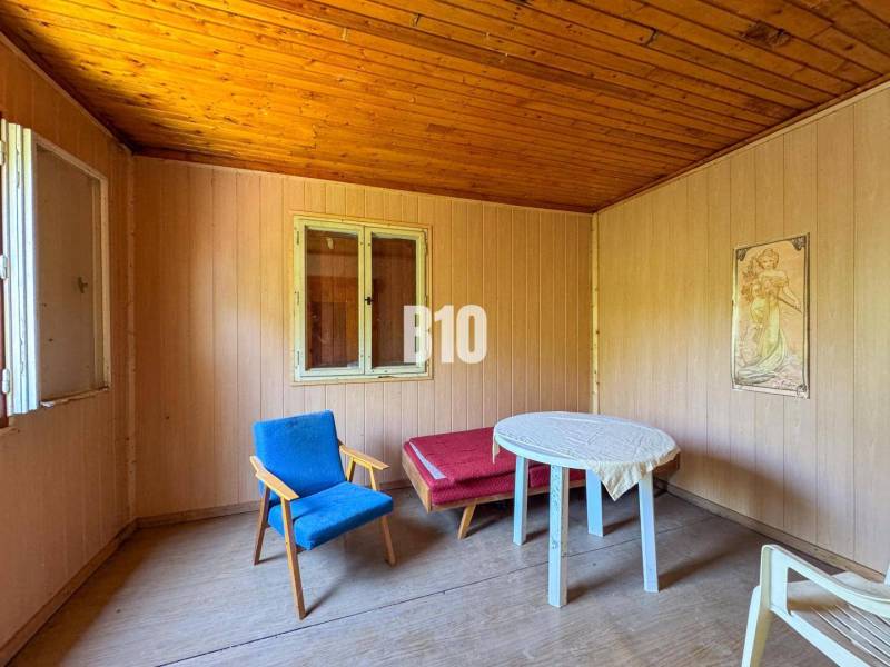 Wooden interior with an armchair, table, and painting, ideal for a vineyard.