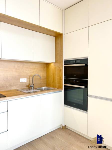 Kitchen unit with storage cabinets in a 2-room apartment, floor with wood decor.