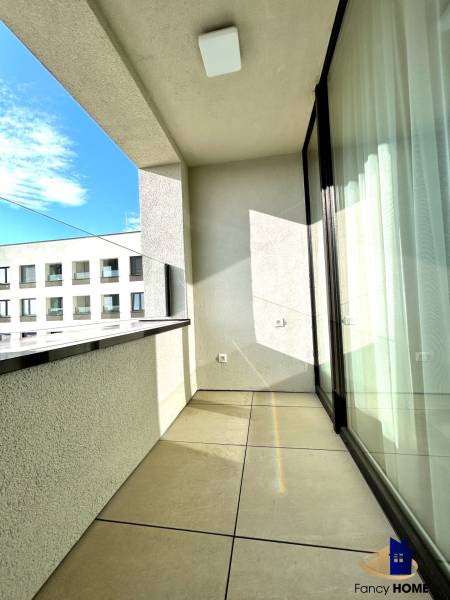 The balcony of a 2-room apartment on Karpatská Street in Poprad with a view of a lower building.