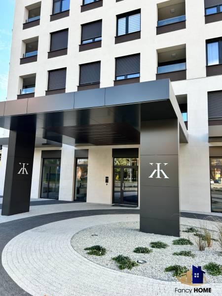 The entrance of the apartment building on Karpatská Street in Poprad with garden landscaping near the 2-room apartments.