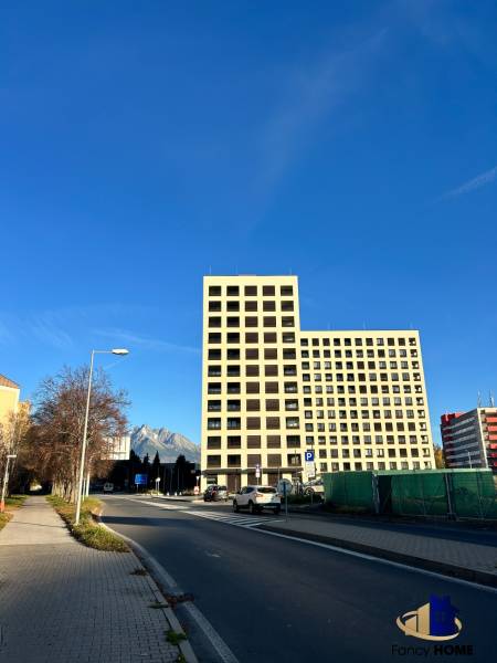 A building on Karpatská Street in Poprad with a view of the Tatras and a blue sky.