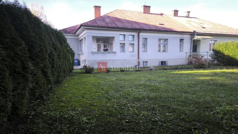 A family house in Uhlisko, Banská Bystrica, surrounded by landscaped greenery, with a veranda.