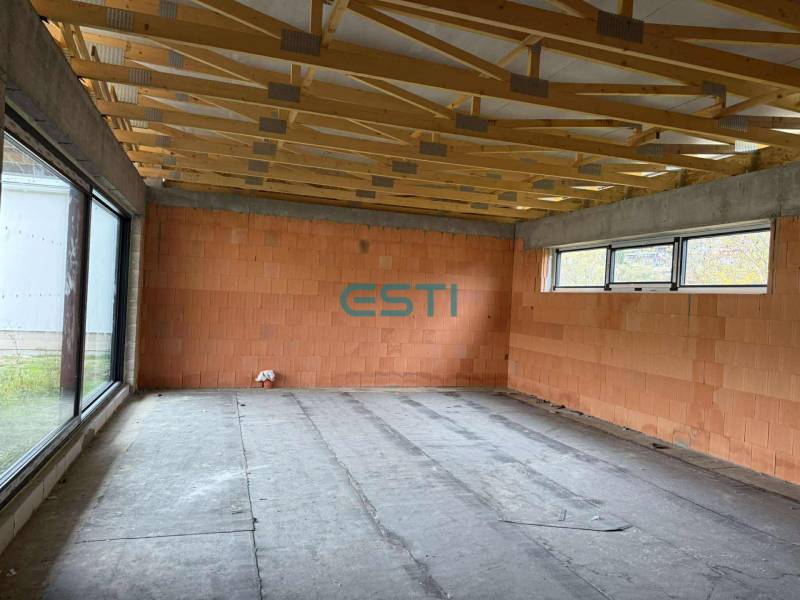 Interior of a family house with a large window and ceiling beams, empty room.