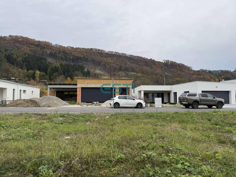 A family house on Na Kúty Street in Teplička nad Váhom with cars and wooded hills.