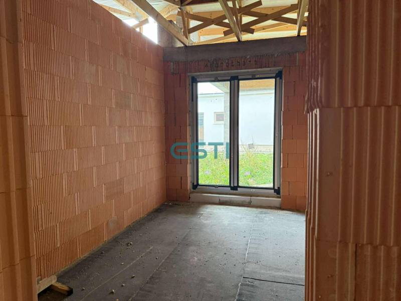 A building in a family house with brick walls and a French window.