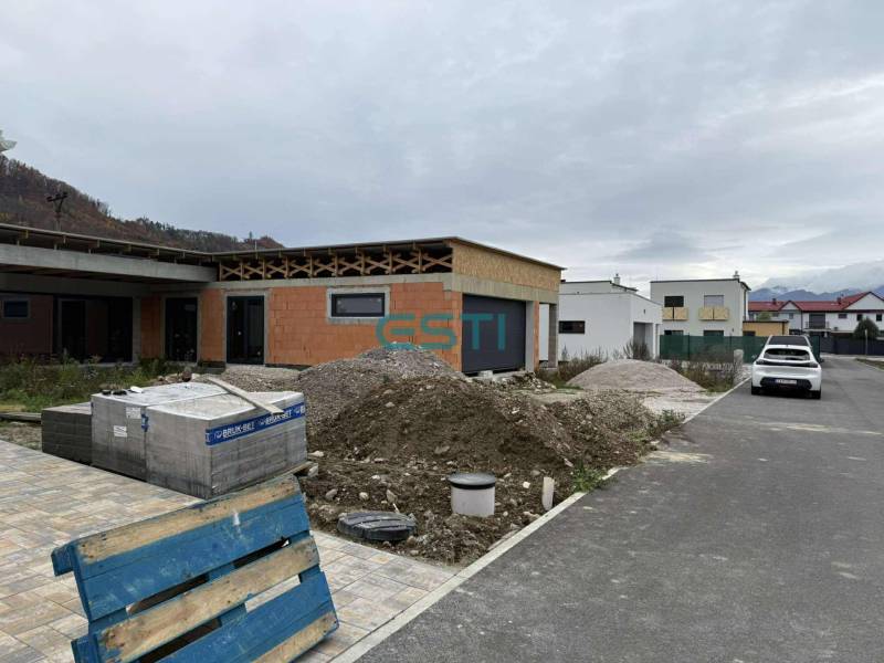 Construction of a family house on Na Kúty Street in Teplička nad Váhom with building materials in front of the house.