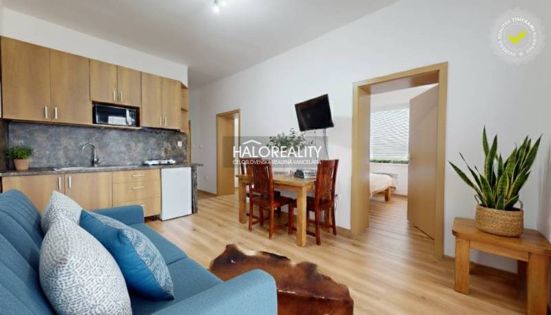 Living room of a 3-room apartment with a wood-patterned floor and comfortable seating.