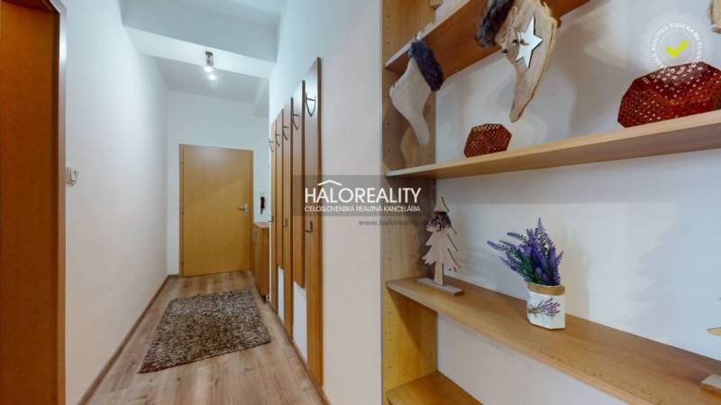 A hallway in a 3-room apartment with decorative shelves and a floor with a wooden decor.