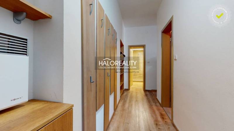 A hallway in a 3-room apartment with a wooden decor floor and a coat rack wall.