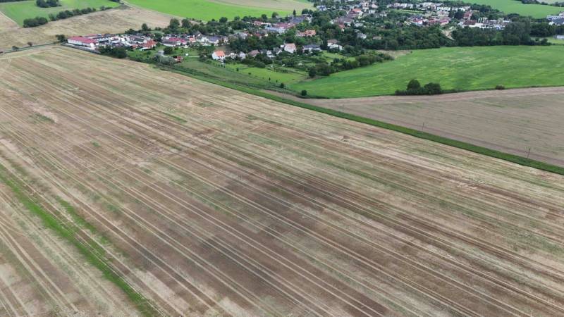 Agricultural and forest land in Nová Ves nad Váhom surrounded by village buildings and greenery.