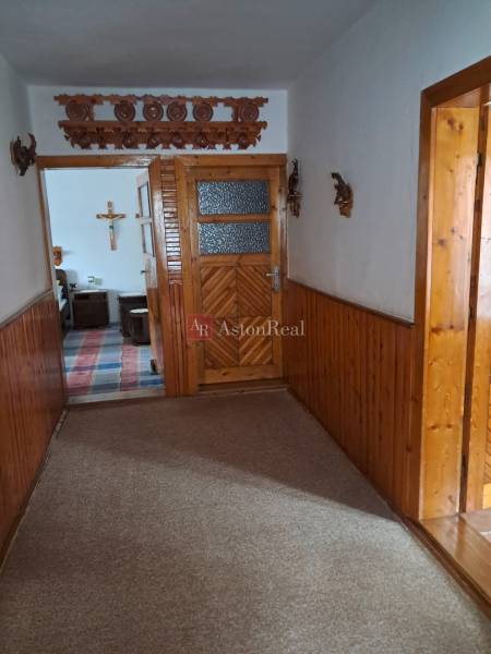 A hallway in a family house with wooden paneling and decorative elements on the wall.