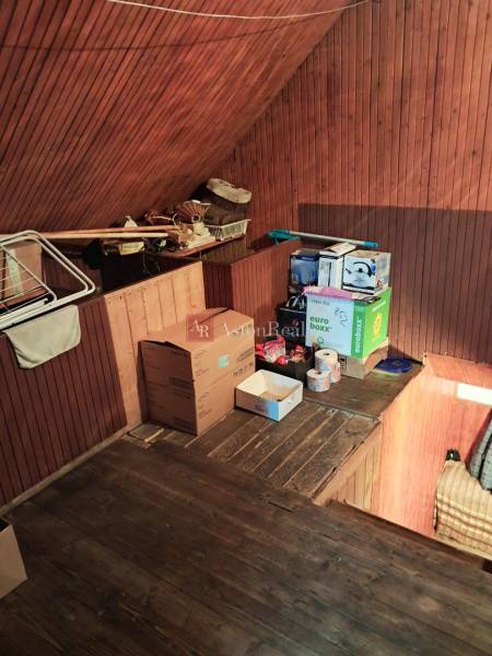 The attic of a family house with storage space, boxes, and a floor with a wooden decor.