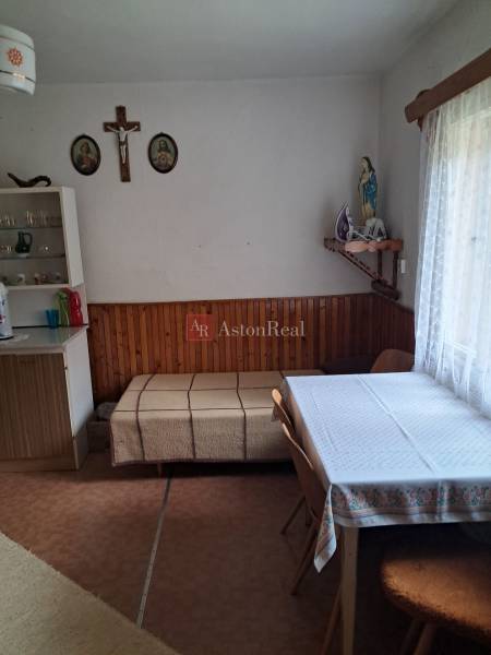 A dining room in a family house with a table, chairs, and religious decorations on the wall.