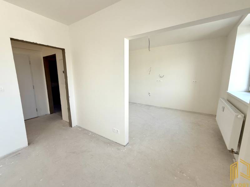 Interior of a 2-room apartment with white walls and prepared outlets for electrical installation.