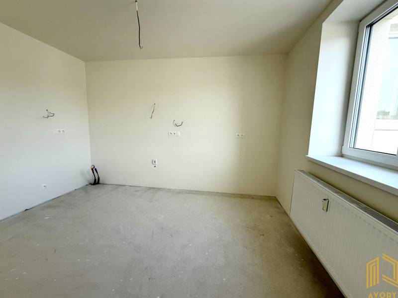A room in a 2-room apartment with walls ready for painting and a radiator by the window.