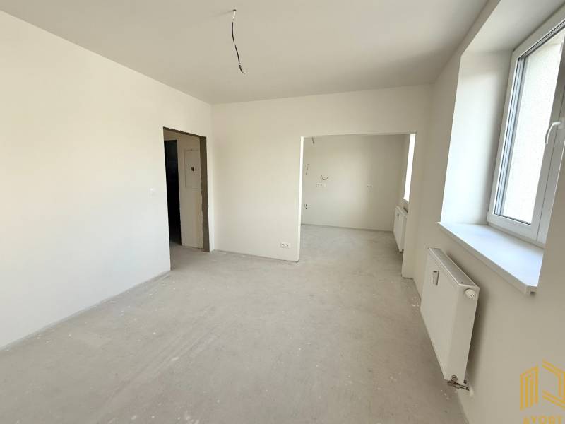 Bright room, spacious window, white walls, and a radiator in a 2-room apartment.