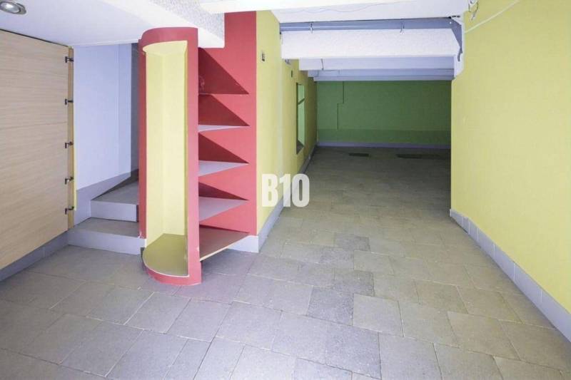 Interior of commercial spaces with colorful walls, shelves, and stairs on the tiles.