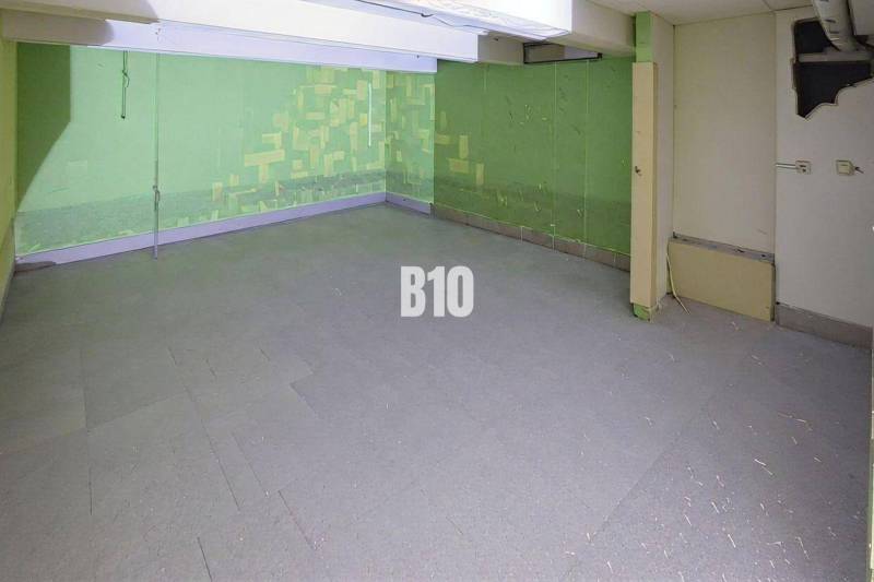 Commercial spaces with concrete floors and green walls.