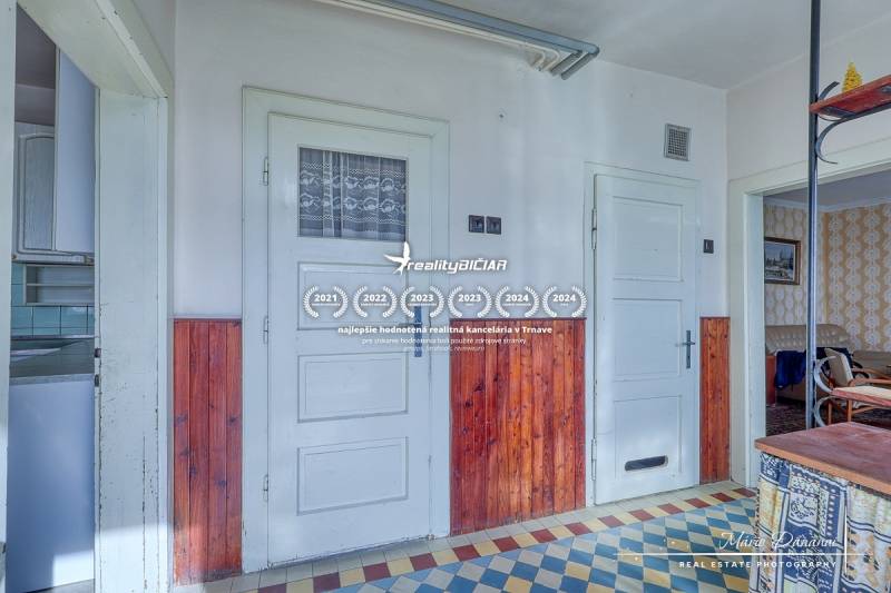 The interior of a family house with a tiled floor and wooden wall paneling.