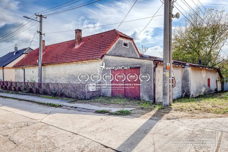 A family house on Dobrá Voda Street in the town of Dobrá Voda with a red roof and a fence.
