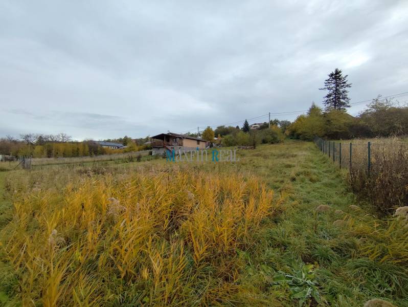 Plots - living in Velky Báb with grass and a view of the surrounding houses and trees.
