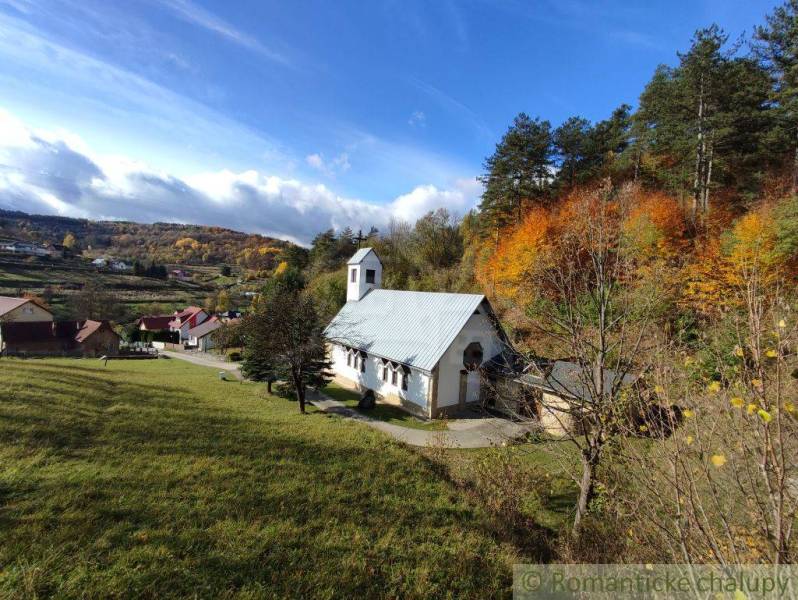 A church surrounded by nature and colorful trees on the outskirts of Hlboké nad Váhom in the gardens.