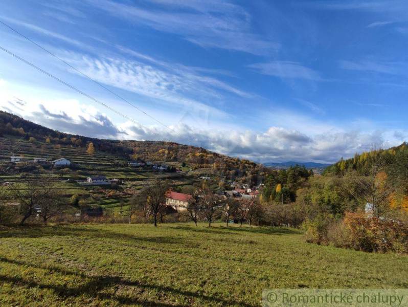 Landscape in Hlboké nad Váhom, gardens with hills and autumn nature under a blue sky.