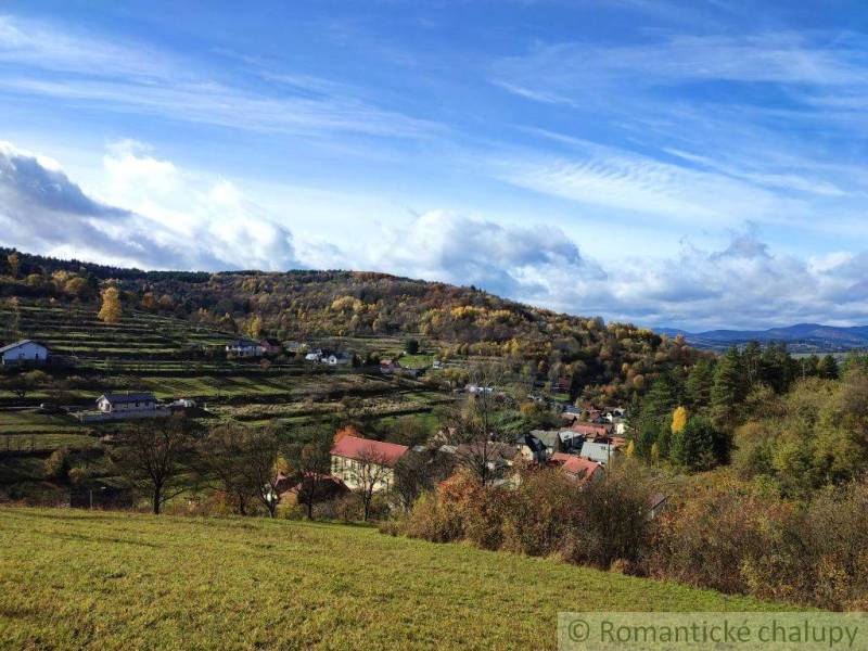 A view of picturesque gardens in Hlboké nad Váhom with a hilly landscape in the background.